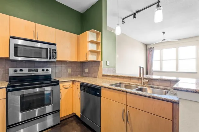 a kitchen with stainless steel appliances a stove sink and microwave