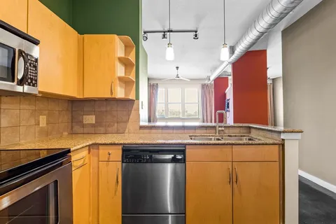a kitchen with stainless steel appliances granite countertop a sink and a microwave