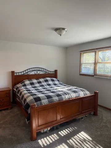a bed sitting in a bedroom next to a window