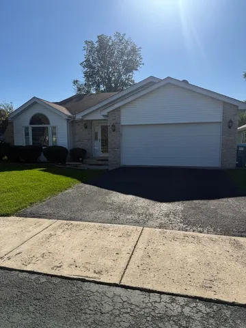 a front view of a house with a yard and a garage