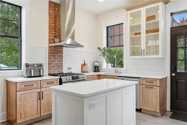 a view of cabinets a sink and a stove in a kitchen