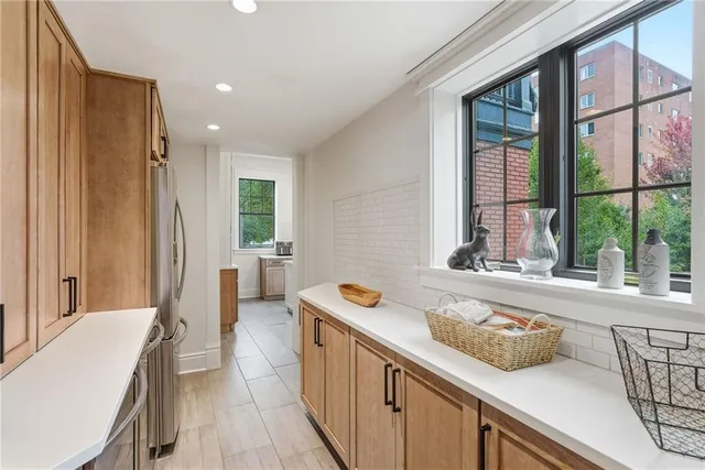 a bathroom with a tub a sink and a large window