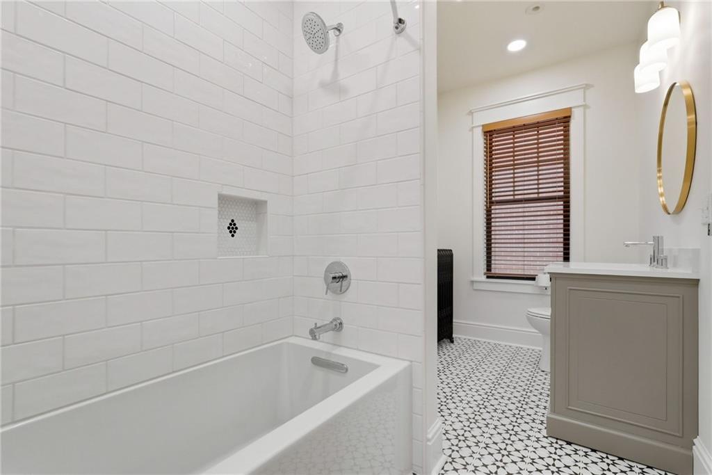 4749 Wallingford Street Pittsburgh, PA 15213 - Photo 38 of 49 a bathroom with a bathtub a sink a toilet and a window
