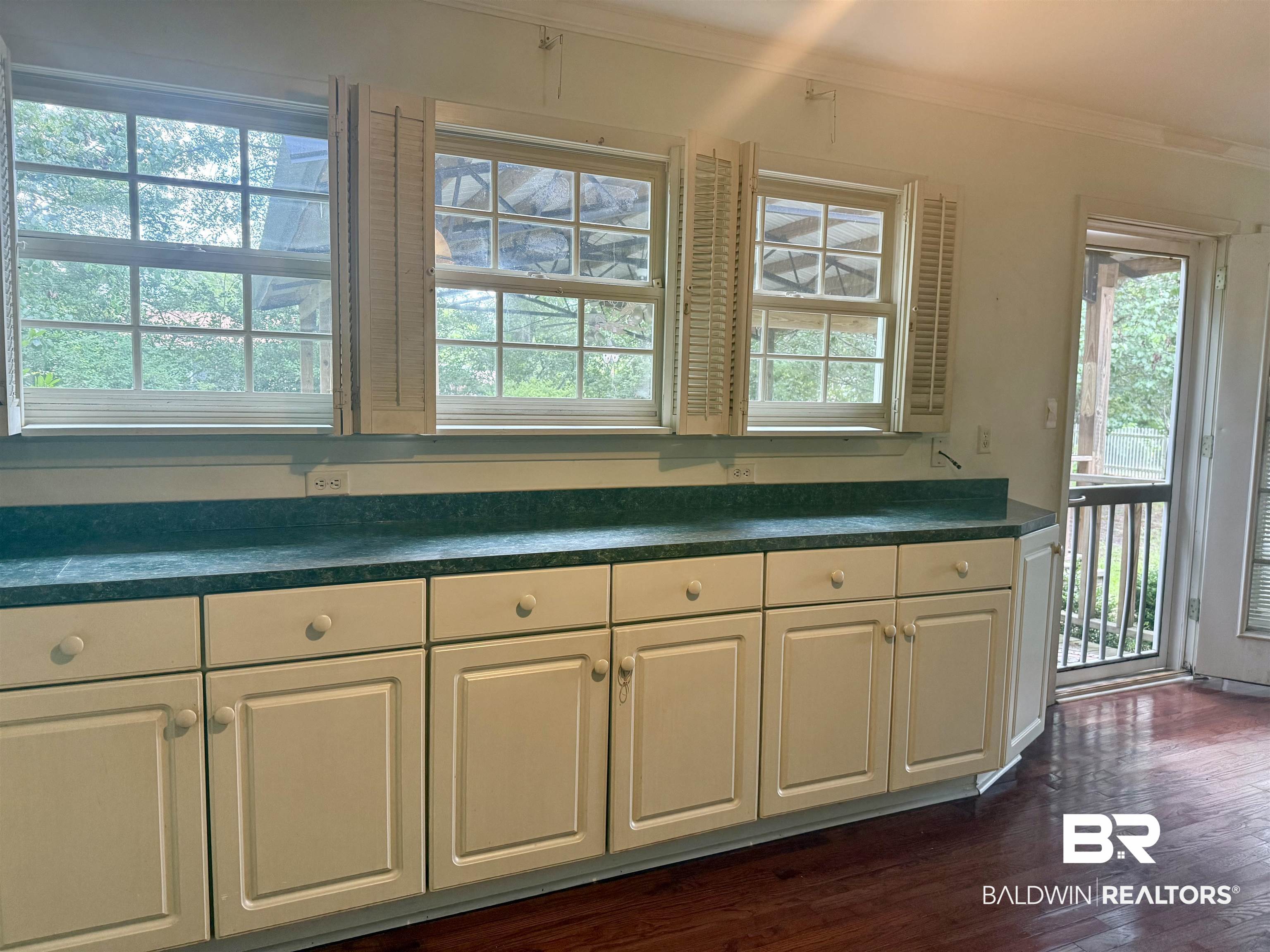 1412 Poplar Avenue Brewton, AL 36426 - Photo 10 of 32 Kitchen featuring white cabinetry, ornamental molding, healthy amount of natural light, dark countertops, and dark wood finished floors