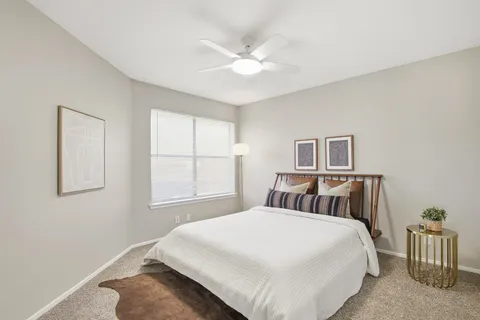 a bedroom with a large bed and a chandelier