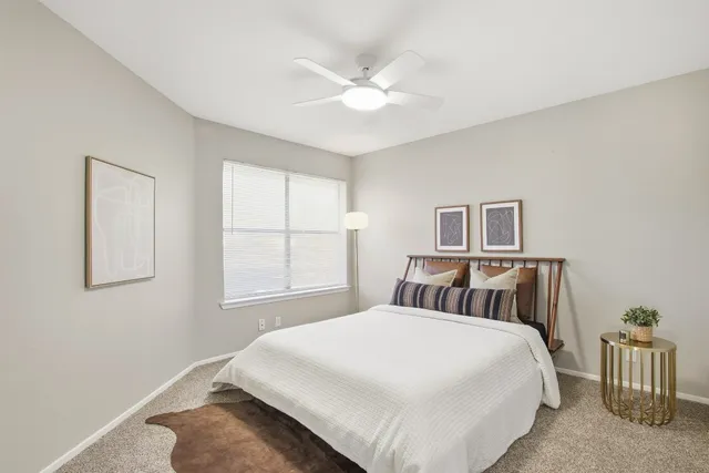 a bedroom with a large bed and a chandelier