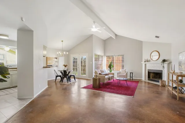 a living room with furniture large window and a fireplace