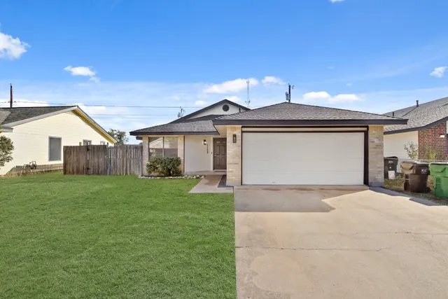 a view of a house with a big yard and large tree