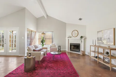a living room with furniture large window and fireplace
