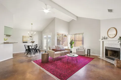 a living room with furniture a dining table and a fireplace