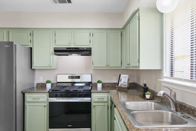 a kitchen with stainless steel appliances granite countertop a sink stove and refrigerator