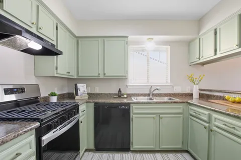 a kitchen with stainless steel appliances granite countertop a sink stove and cabinets