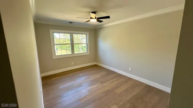 an empty room with a window and a ceiling fan
