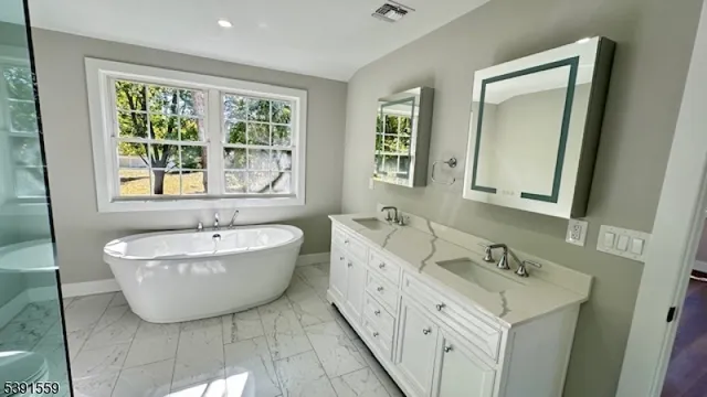 a spacious bathroom with a bathtub and 2 sink