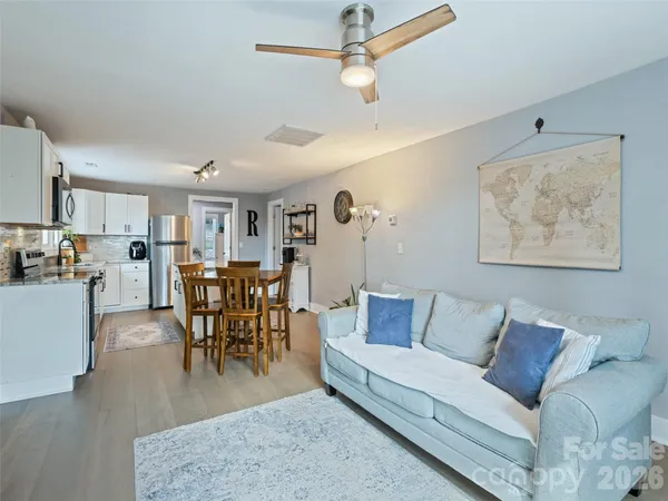 a kitchen with a table chairs microwave and window