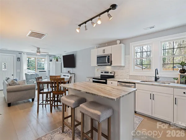 a large kitchen with cabinets table and chairs