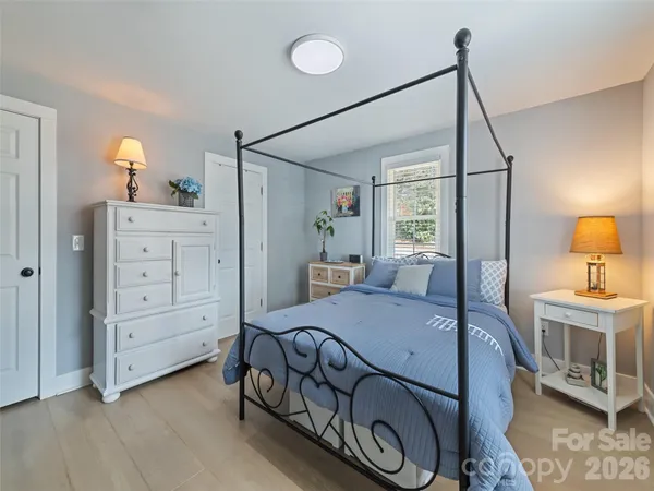 a bedroom with a bed a dresser and next to a window