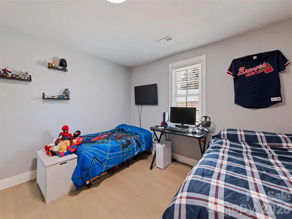 a bedroom with a bed and painting on the wall