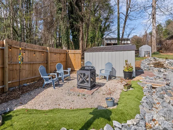 a view of a backyard with chairs and a fire pit