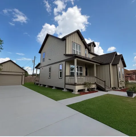 a front view of a house with a garden and yard