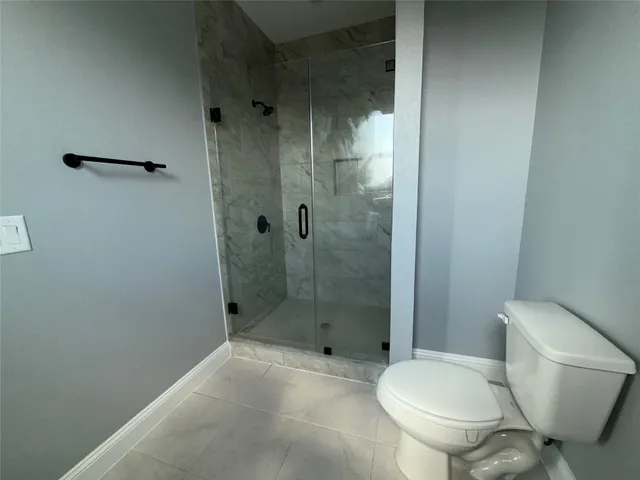 a bathroom with a toilet and a shower