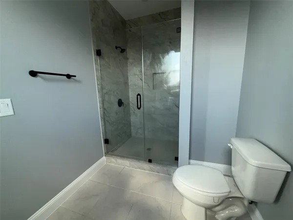 a bathroom with a toilet and a shower