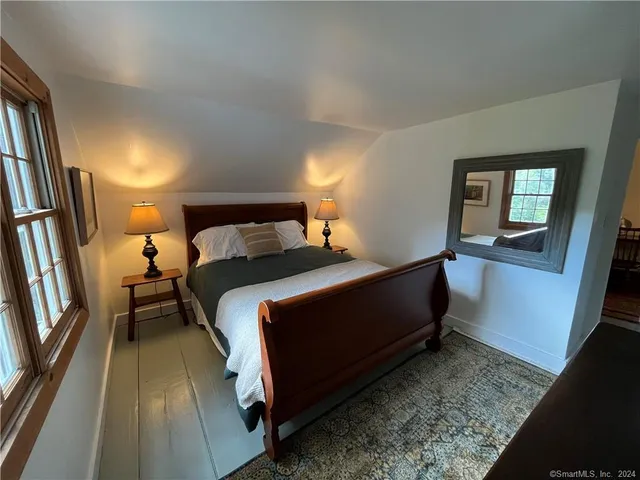 a bedroom with a bed and a mirror on dresser