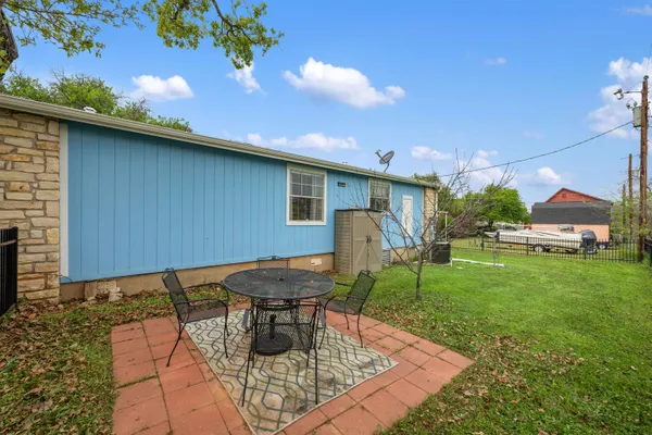 a backyard of a house with table and chairs