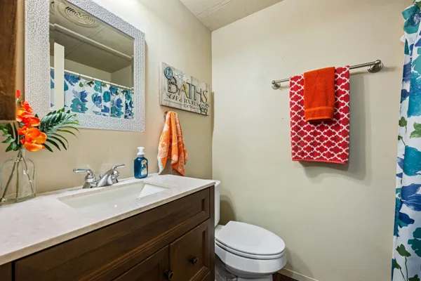 a bathroom with a sink mirror vanity and toilet