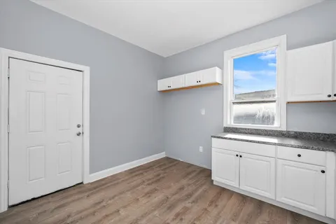 a kitchen with granite countertop a sink cabinets and wooden floor