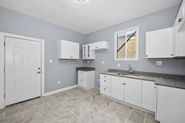 a kitchen with granite countertop a sink and cabinets