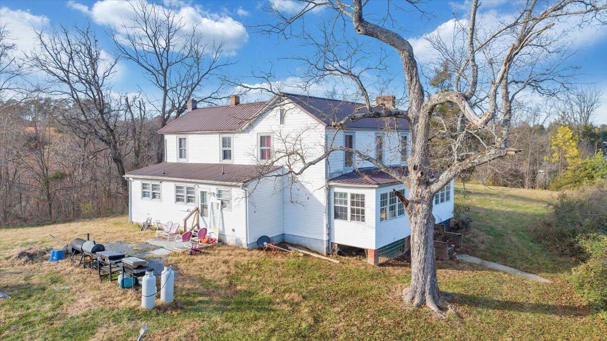 6457 Roanoke Road Fincastle, VA 24090 - Photo 23 of 34 a view of a white house with a large tree and wooden fence