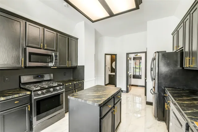 a kitchen with stainless steel appliances granite countertop a stove and a refrigerator