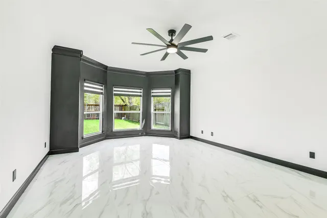 a view of an empty room with a ceiling fan