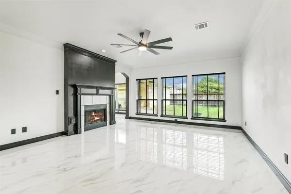 a view of an empty room with a fireplace and a window