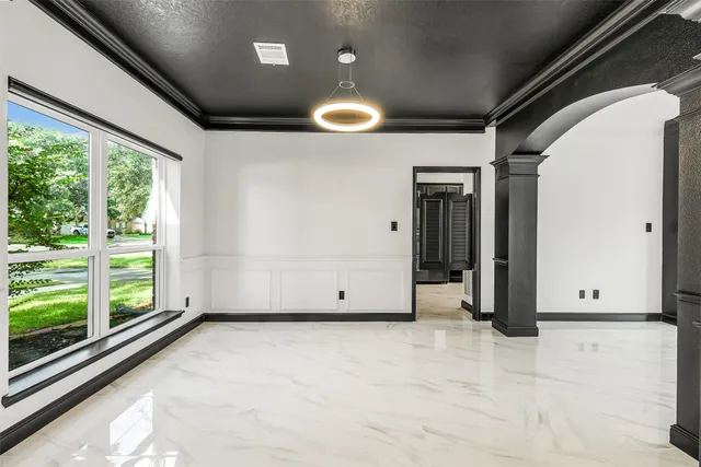 a view of an empty room with wooden floor and windows