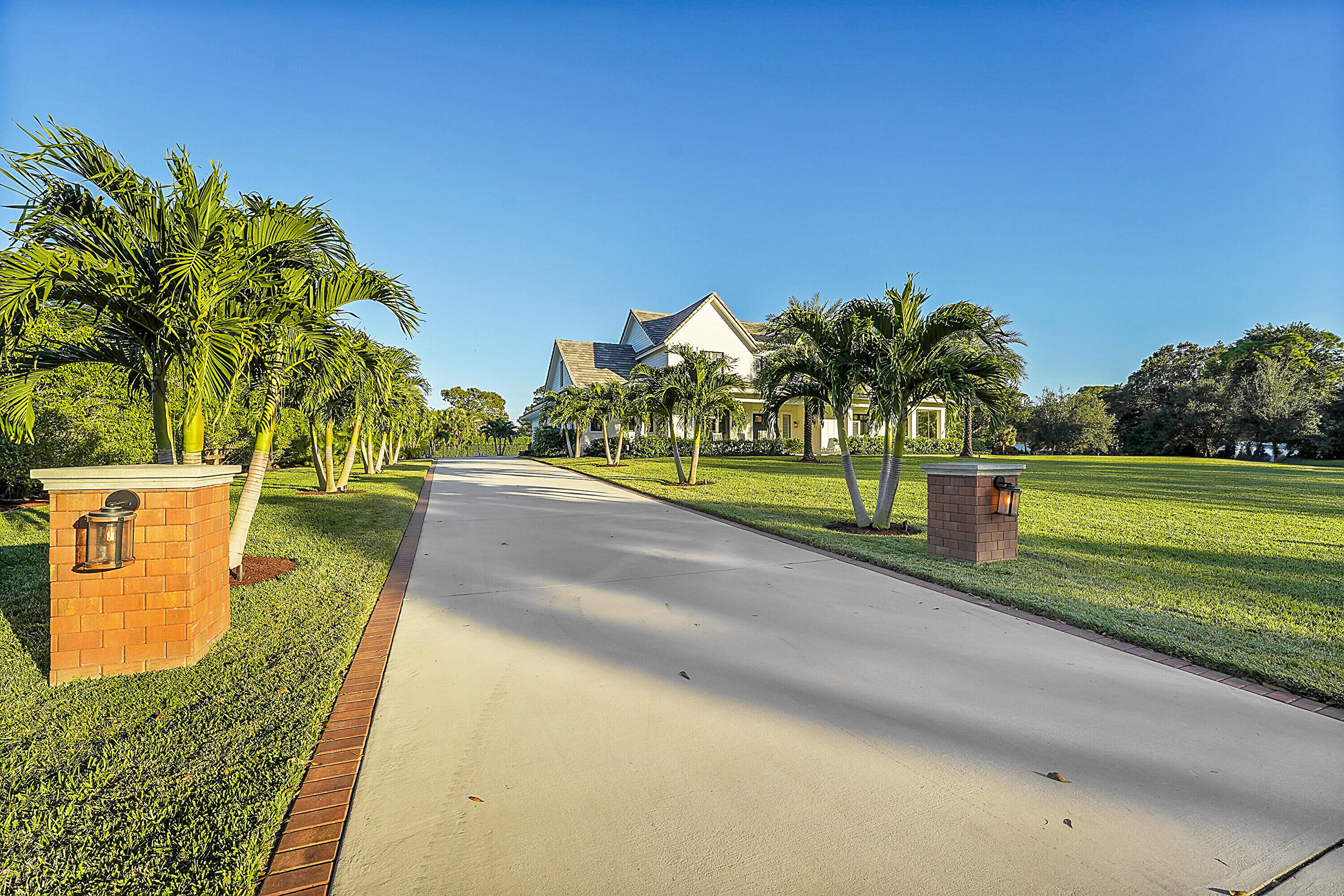 7660 Bold Lad Road Palm Beach Gardens, FL 33418 - Photo 55 of 68 a view of a swimming pool with a yard and palm trees