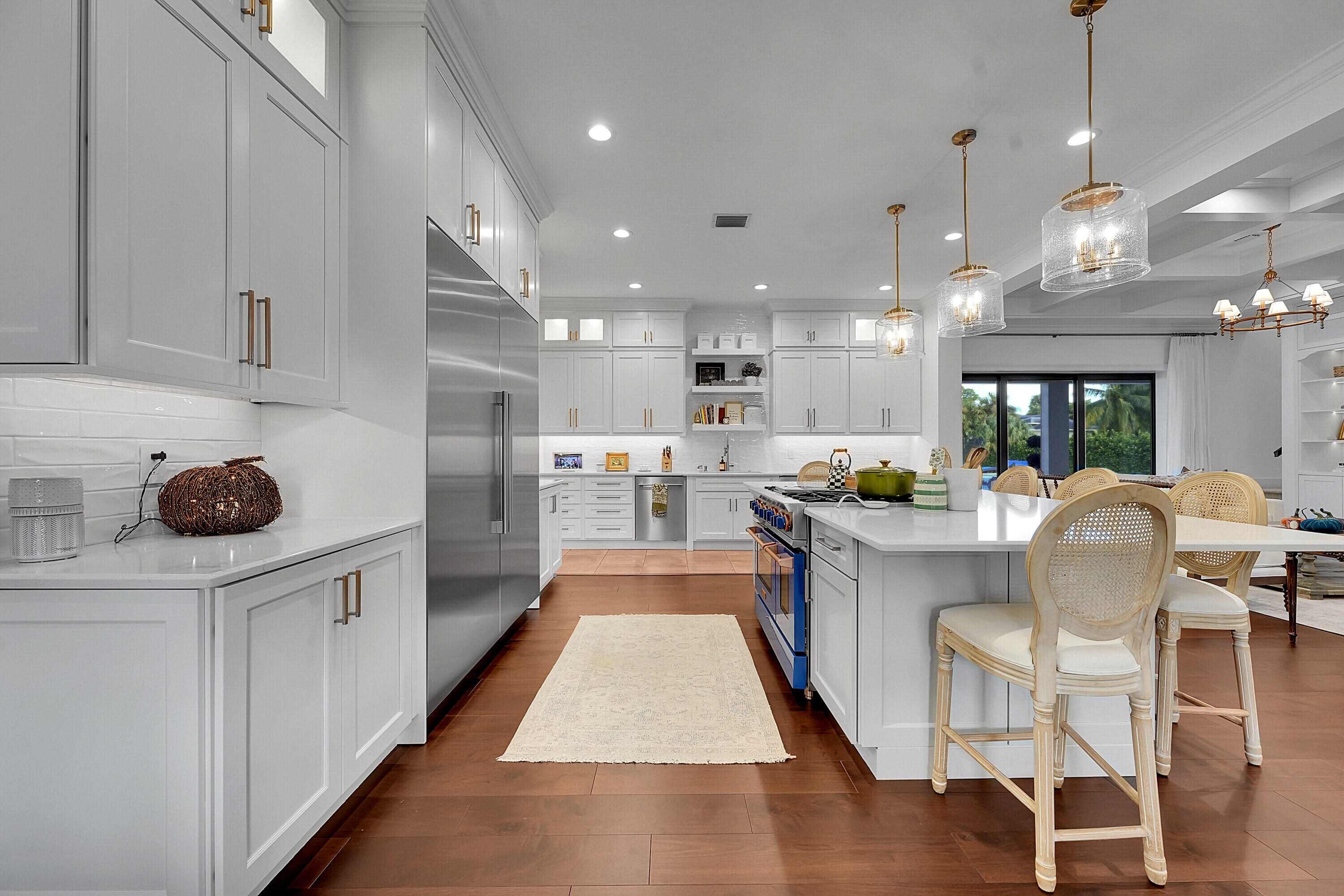 7660 Bold Lad Road Palm Beach Gardens, FL 33418 - Photo 7 of 68 a large kitchen with kitchen island a large counter space a sink stainless steel appliances and cabinets