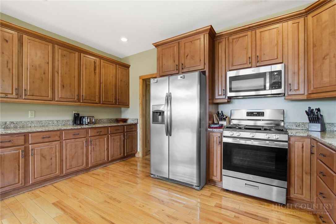 2081 Blackberry Road Boone, NC 28607 - Photo 22 of 45 a kitchen with stainless steel appliances granite countertop a stove a sink dishwasher a refrigerator and cabinets with wooden floor