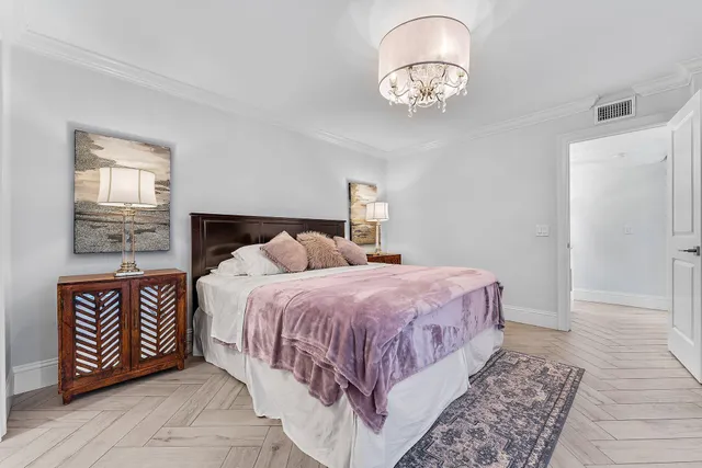 a bedroom with a bed and a chandelier