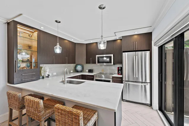 a kitchen with stainless steel appliances granite countertop a refrigerator a sink and a stove