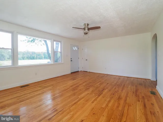 wooden floor in an empty room with a window