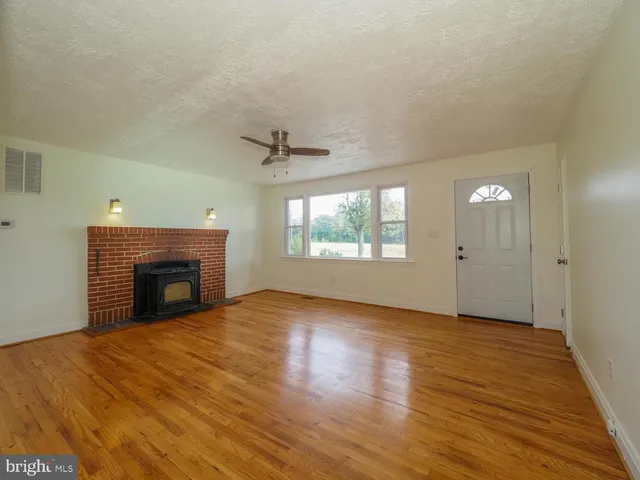 wooden floor fireplace and windows in an empty room