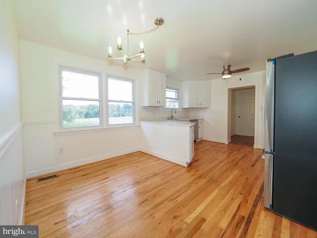 a view of a kitchen with wooden floor and a window