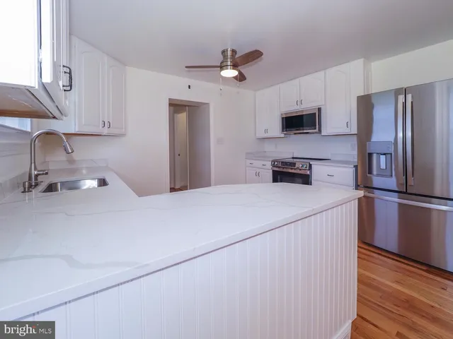 a kitchen with stainless steel appliances a refrigerator sink and microwave