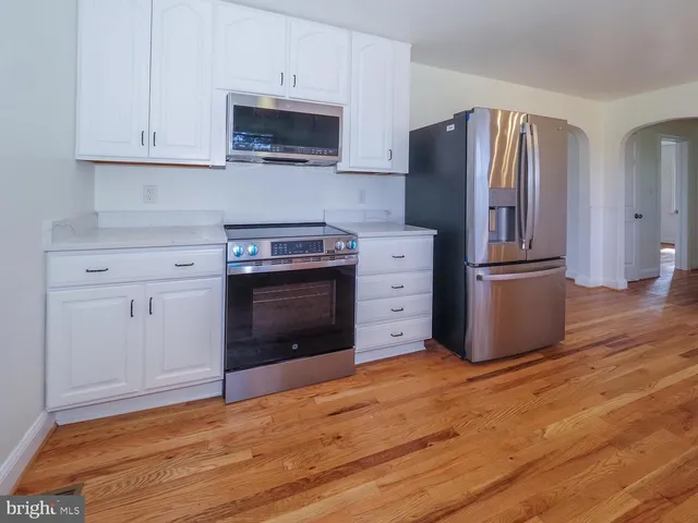 a kitchen with granite countertop a refrigerator stove and oven