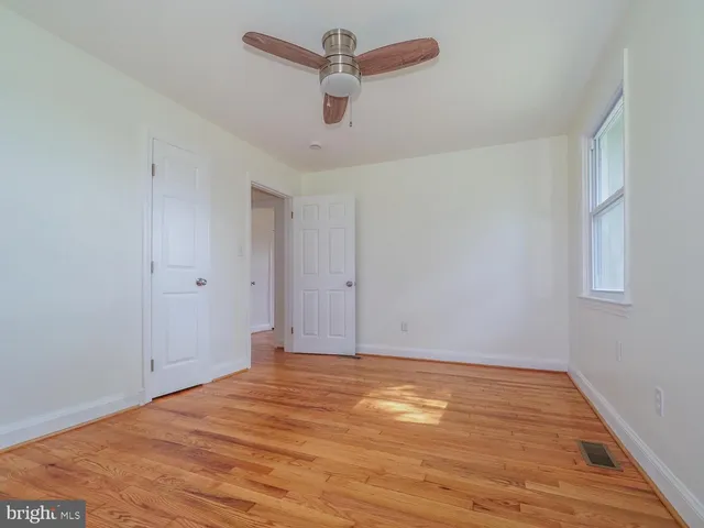 a view of room with wooden floor and ceiling fan