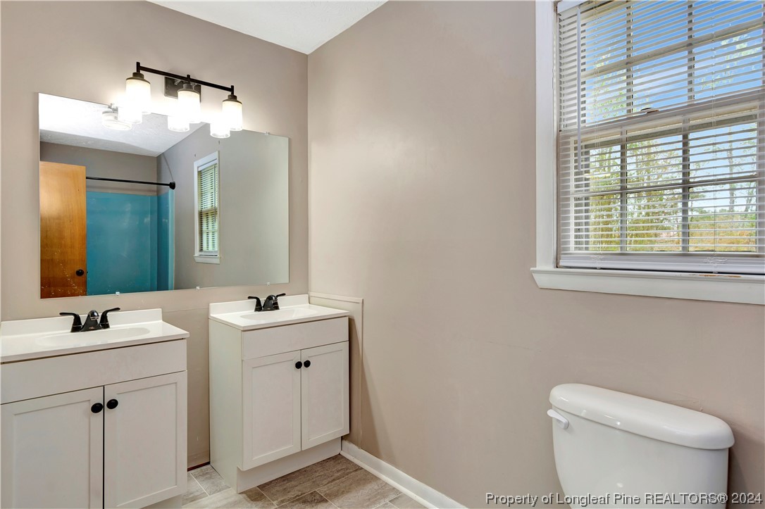 527 Old Allenton Road Lumberton, NC 28358 - Photo 16 of 20 a bathroom with a toilet sink and mirror