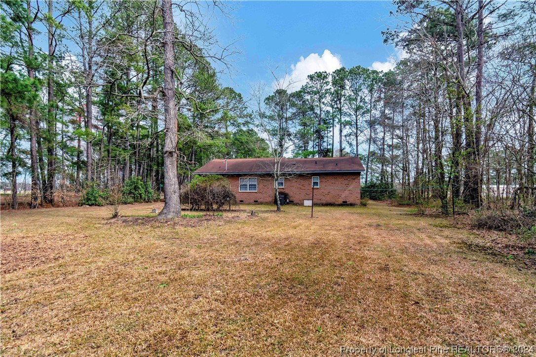 527 Old Allenton Road Lumberton, NC 28358 - Photo 20 of 20 a backyard of a house with wooden fence and large trees