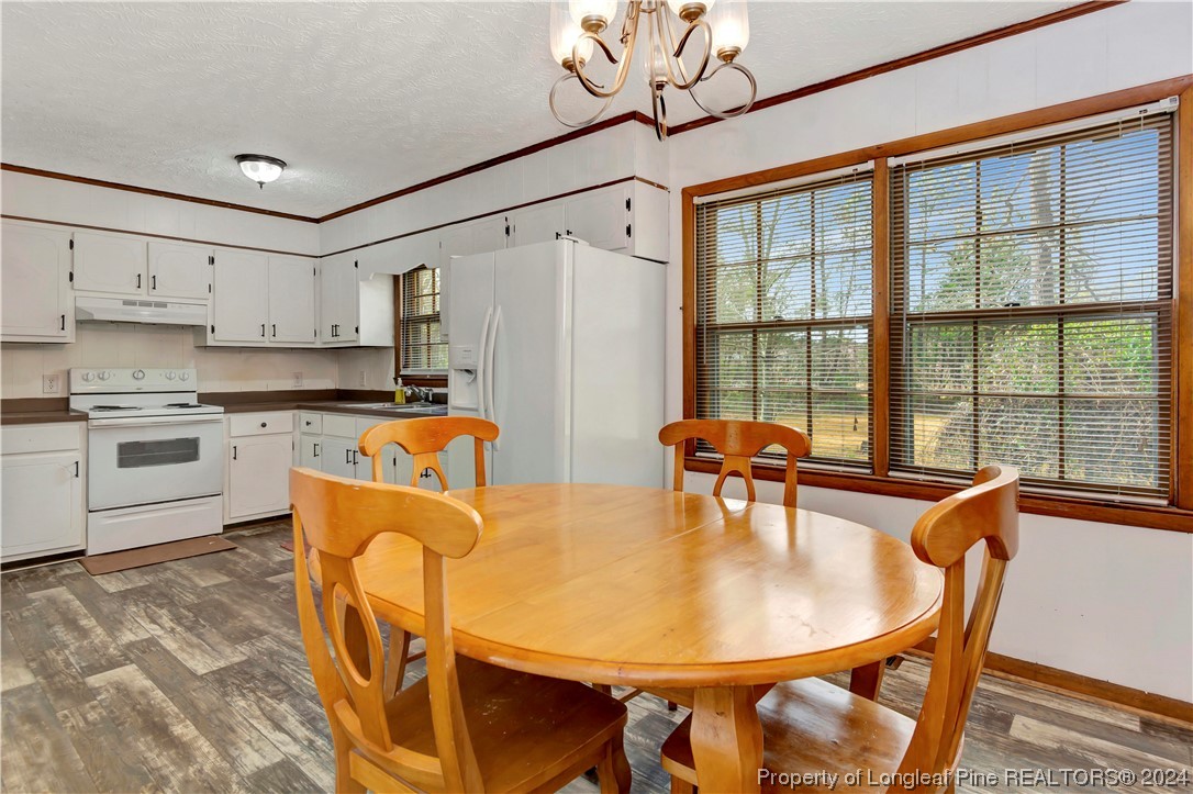 527 Old Allenton Road Lumberton, NC 28358 - Photo 8 of 20 a kitchen with stainless steel appliances granite countertop a stove a refrigerator a dining table and chairs with wooden floor